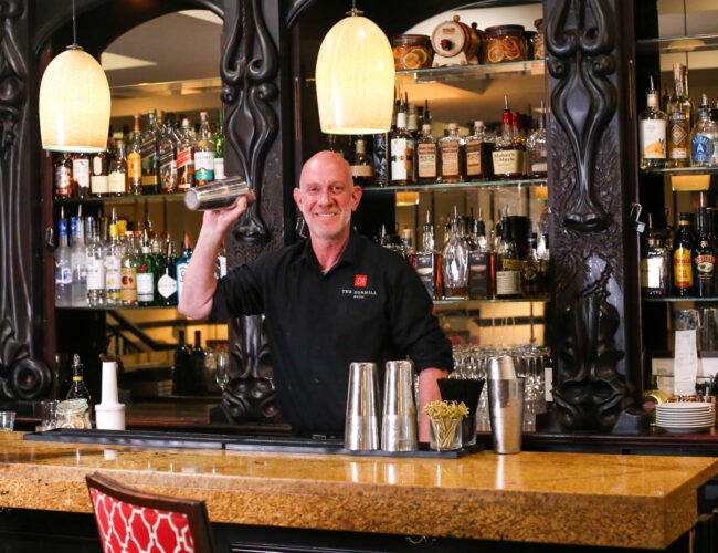 bartender smiling shaking cocktail at the dunhill bar