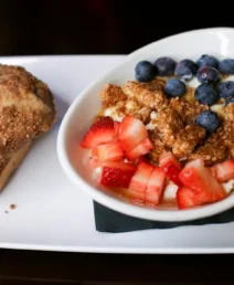 Delicious breakfast with fresh fruit granola and muffin at boutique hotel restaurant.