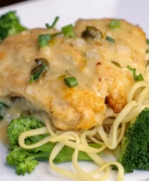 A gourmet chicken and broccoli pasta dish served on a white plate.