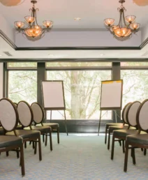 Elegant meeting room with chairs, windows, and flipcharts at The Dunhill Hotel.