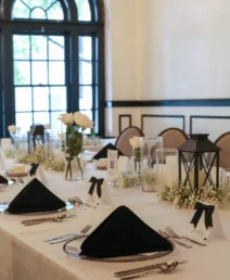 Elegant dining table set for guests at The Dunhill Hotel, Charlotte, with florals and lanterns.