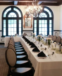 Elegant dining room in The Dunhill Hotel set for a family gathering with chandeliers.