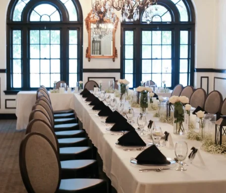 Elegant dining room in The Dunhill Hotel set for a family gathering with chandeliers.