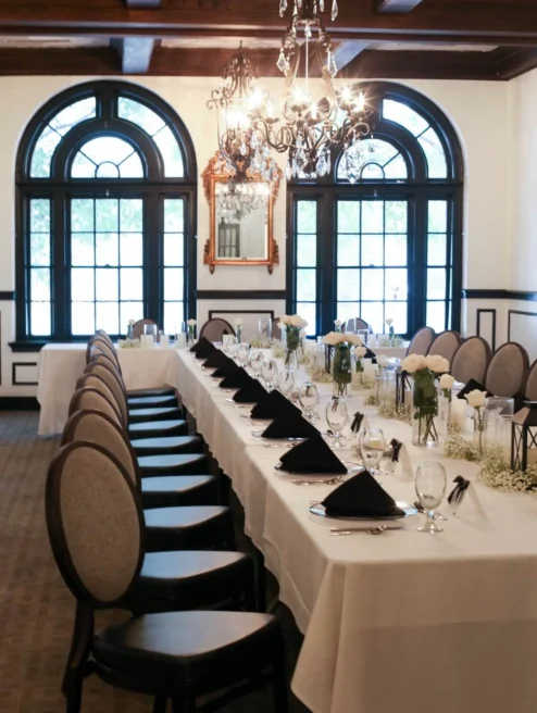 Elegant dining room in The Dunhill Hotel set for a family gathering with chandeliers.