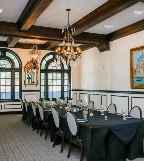 Elegant dining room with chandelier, set for a family gathering at The Dunhill Hotel.