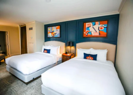 Elegant twin bedroom in The Dunhill Hotel with modern art and plush bedding.