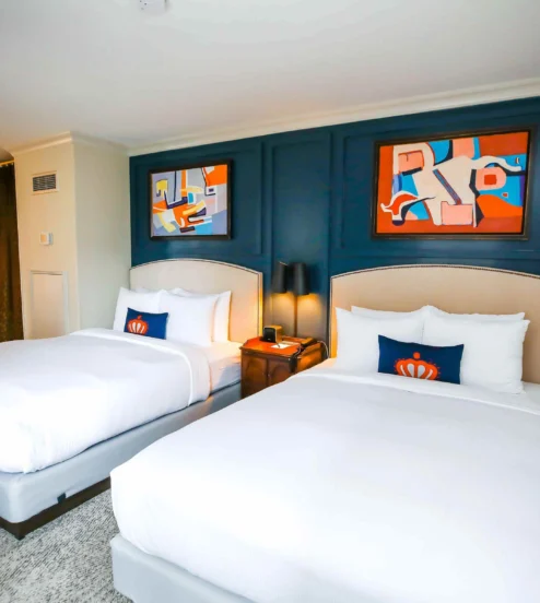 Elegant twin bedroom in The Dunhill Hotel with modern art and plush bedding.