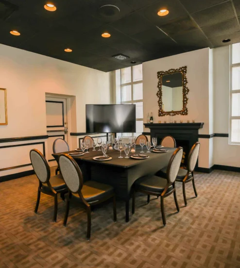 Elegant dining room setup in the Dunhill Hotel, featuring a large table and ambient lighting.