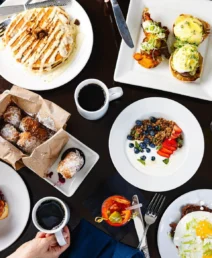 Family enjoying a gourmet breakfast with pancakes, eggs Benedict, and pastries at The Dunhill Hotel.