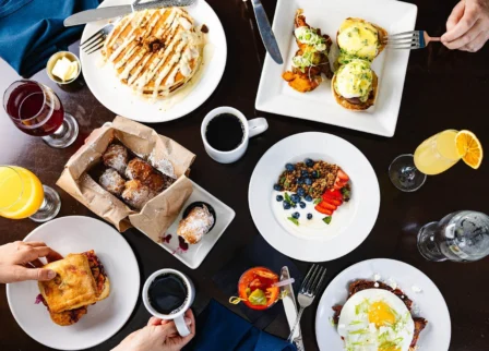 Family enjoying a gourmet breakfast with pancakes, eggs Benedict, and pastries at The Dunhill Hotel.
