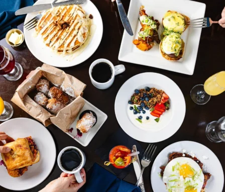 Family enjoying a gourmet breakfast with pancakes, eggs Benedict, and pastries at The Dunhill Hotel.