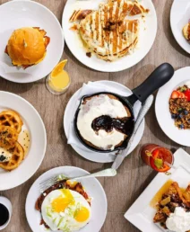 Delicious breakfast spread with waffles, pancakes, pastries, and beverages at a boutique hotel.