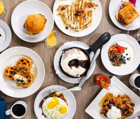 Delicious breakfast spread with waffles, pancakes, pastries, and beverages at a boutique hotel.