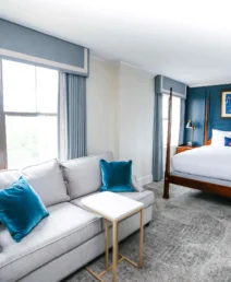 Spacious, elegant hotel room with a cosy bed and sitting area.