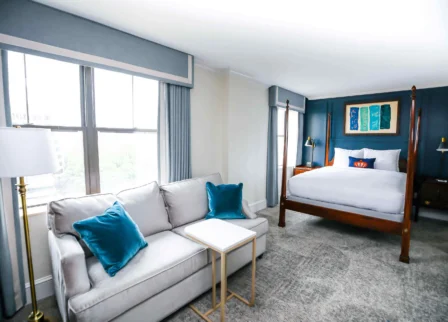 Spacious, elegant hotel room with a cosy bed and sitting area.