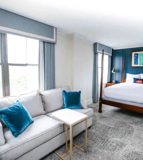 Spacious, elegant hotel room with a cosy bed and sitting area.