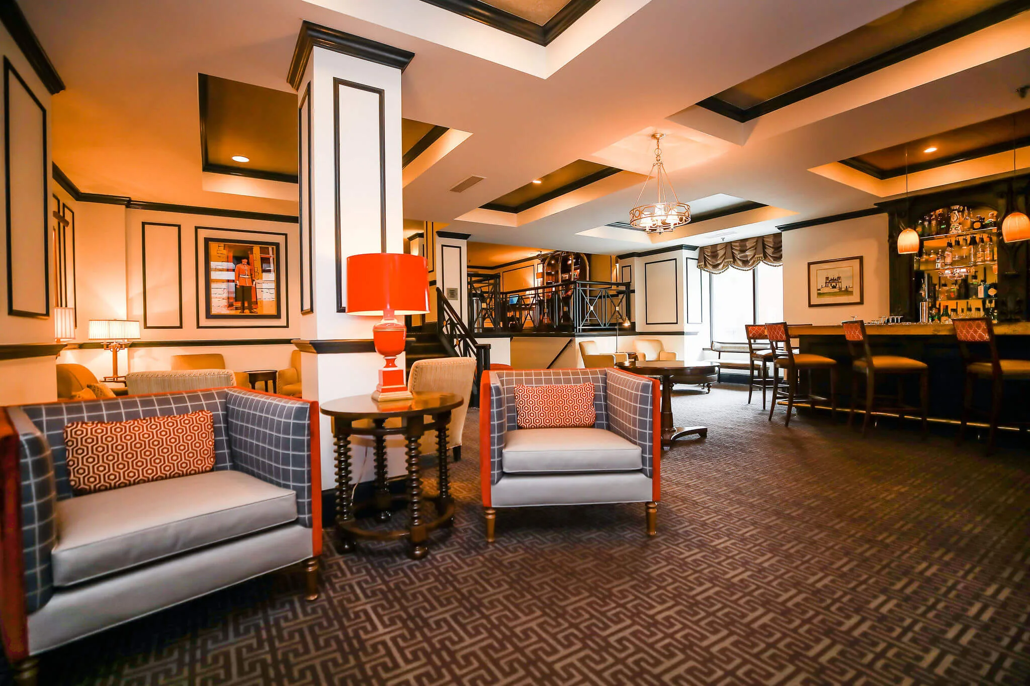 A hotel lobby with a sofa, armchairs, a coffee table, and a lamp.